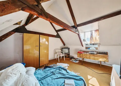 bedroom with beams on ceiling and bed