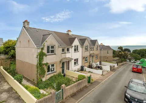 row of terraced houses with sea in the distance
