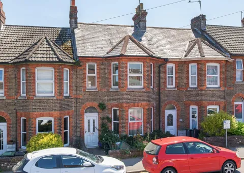 exterior of a mid terrace brick built house with white front door