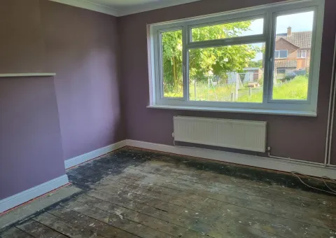 interior of lounge with pink walls and floorboards