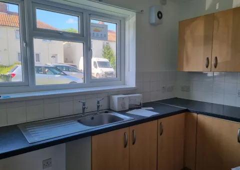 interior of kitchen showing light brown cabinets and cupboards and black surfaces
