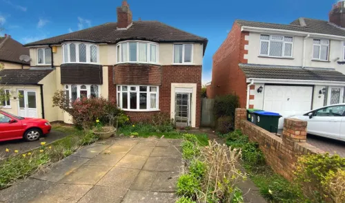 Red brick semi-detached house with bay windows, paved driveway, and front garden.