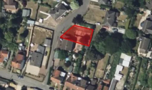 Aerial view of a residential property with a red outline highlighting the plot.