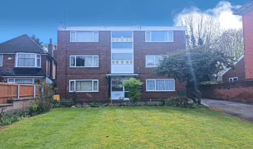 Kingsbury Court, a brick apartment building with green lawn and trees.