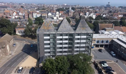 Modern office building with three pointed roofs, aerial view.