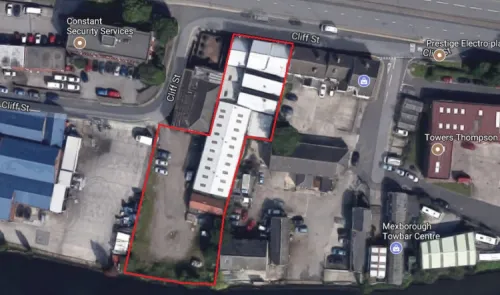Aerial view of commercial property on Cliff St, outlined in red, with surrounding businesses and a river.