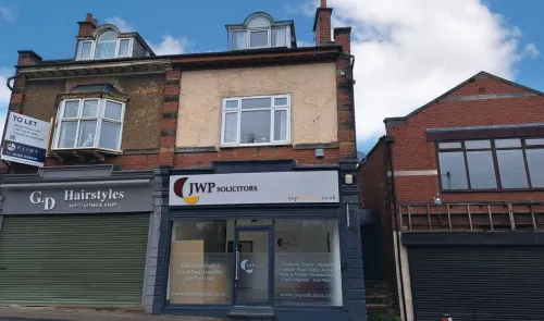 Mixed-use building exterior with "JWP Solicitors" and "G&D Hairstyles" storefronts. Space available "To Let.