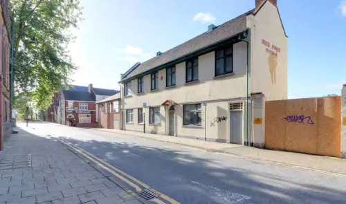 Rees Jones dental surgery exterior, two-story cream building, street view, sunny day.