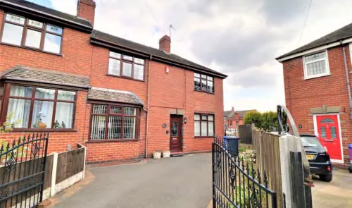 Red brick semi-detached house with driveway and gated entrance.