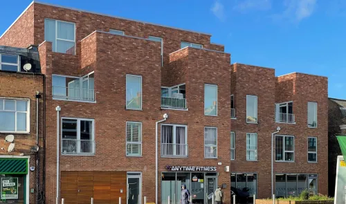 Modern red brick mixed-use development with "Anytime Fitness" at street level. CGI of proposed development.