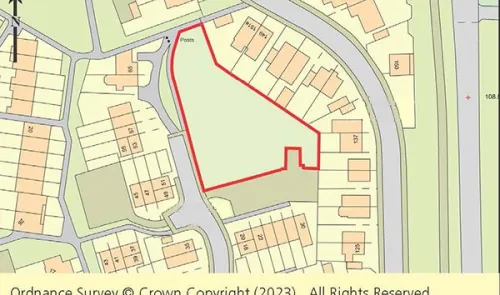 Ordnance Survey map highlighting a vacant plot outlined in red within a residential area.