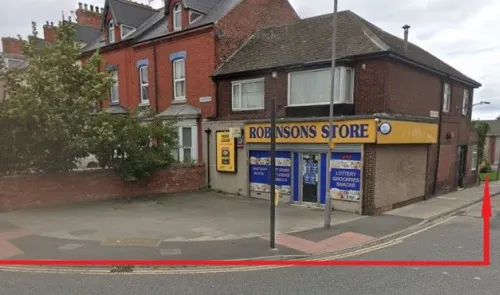 Robinsons Store" convenience shop exterior, with brick building and street view.