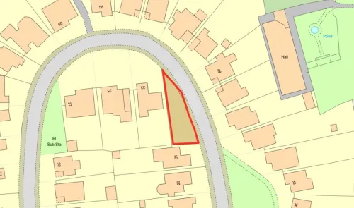 Triangular plot of land highlighted in red on a map, showing adjacent properties and a nearby road.