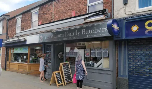 Vince Lunn Family Butchers storefront with customers, signage, and daily specials advertised.
