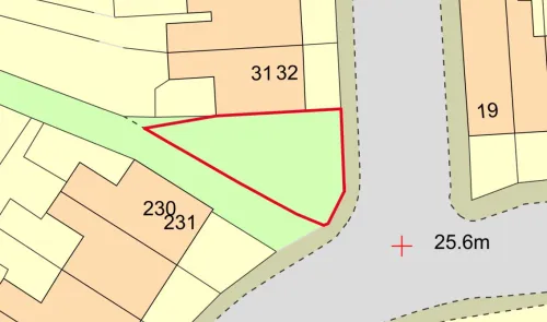 Map highlighting a triangular green plot outlined in red, adjacent to a road.
