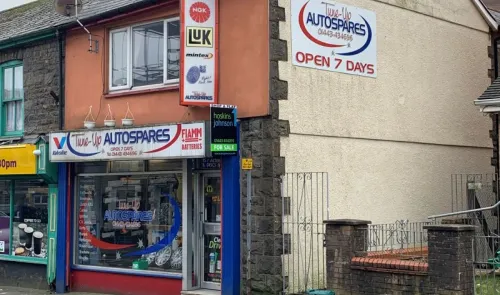 Tune-Up Autospares" storefront, displaying car parts and signage indicating open 7 days.