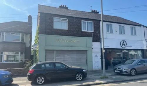 Elsie's Croft" storefront with closed shutters between other businesses on a sunny street.
