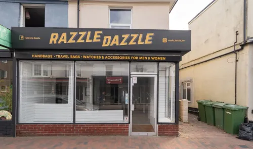Razzle Dazzle" storefront selling handbags, travel bags, watches, and accessories.