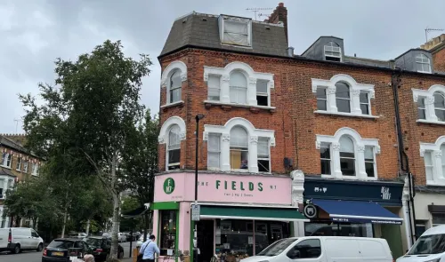 The Fields" greengrocer shop in a pink and brick building, London, N7.