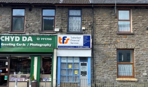 Treherbert Financial Services storefront between a greeting card shop and a stone residential building.