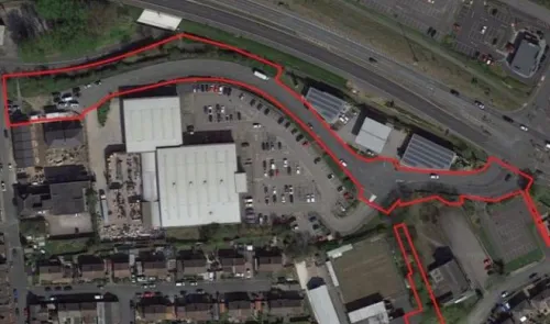 Aerial view of commercial property with red outline marking boundaries, parking lot, and adjacent highway.