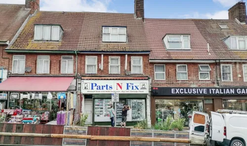 Brick storefront with "Parts N Fix" shop between other businesses.