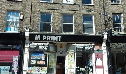 M Print" storefront, offering printing, t-shirts, and gifts. Display windows showcase examples.