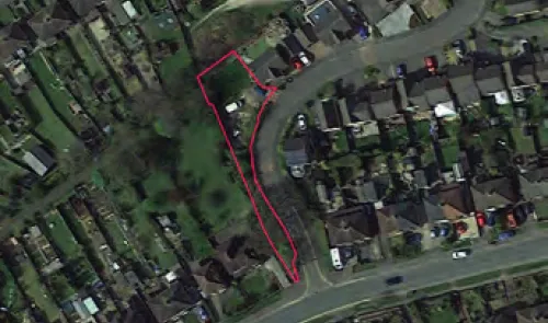 Aerial view of land outlined in red, showing its position within a residential area.