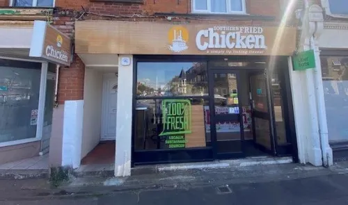 Southern Fried Chicken storefront. Sign boasts "a simply lip licking flavour". Window decal: "100% Fresh, Locally, Sustainabl