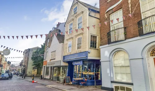 Charming street scene with shops and Union Jack bunting in a historic UK town.