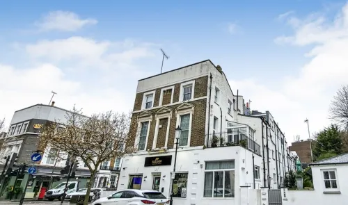 White and brick building with "Salt Craft" signage, street view, parked cars, and blossoming tree.