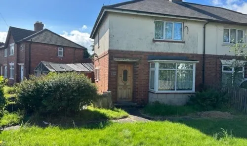 Semi-detached house with brick and off-white facade, front garden, and bay window.