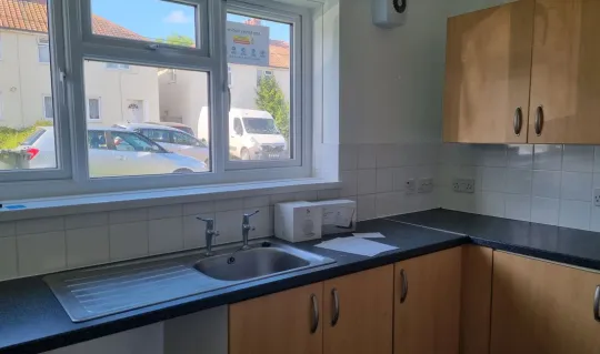 interior of kitchen showing light brown cabinets and cupboards and black surfaces